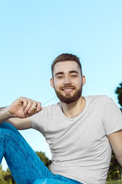 Parkta oturan yakışıklı genç adam