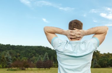 Genç adam parkta dinleniyor.