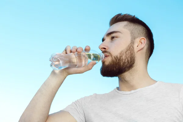Young man drinking water, hot day — Stock Photo, Image