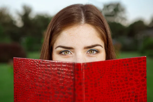 Hermosa chica en el parque con un libro — Foto de Stock