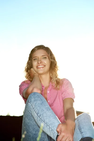 Vacker ung kvinna sitter på gräset — Stockfoto