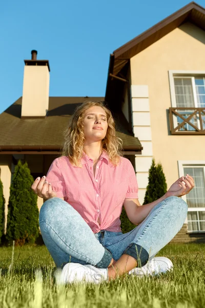 Young woman meditating in the front yard — Stock Photo, Image