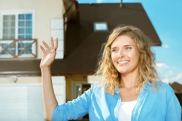 Genç kız sokakta yeni evine duruyor.