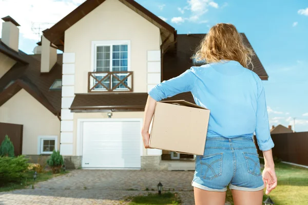 Mujer joven llevando cajas a casa nueva —  Fotos de Stock