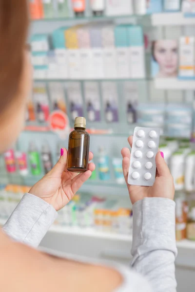 Hermosa chica no puede decidir qué comprar en la farmacia — Foto de Stock