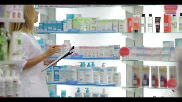 Фармацевт ведет учет продукта в аптеке — стоковое видео