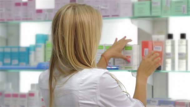 Farmacéutico al frente del producto en farmacia — Vídeo de stock