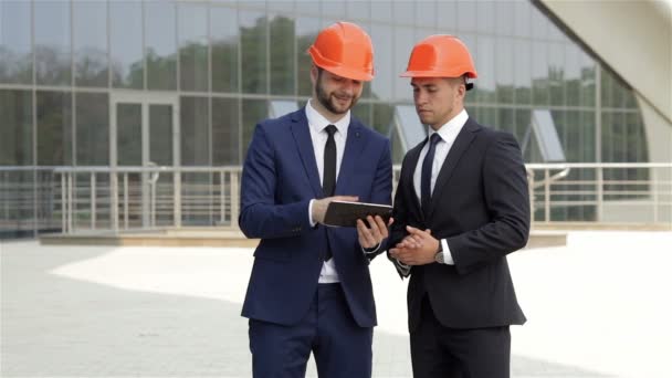 Dois arquitetos usando um tablet ao ar livre — Vídeo de Stock