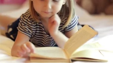 Küçük kız kitap okuyor.