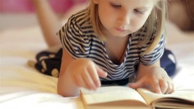 Küçük kız kitap okuyor.