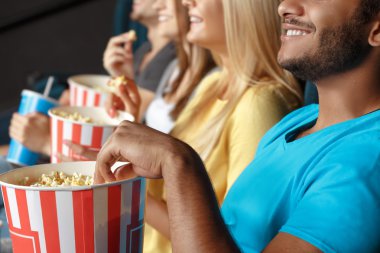 Friends eating popcorn at the movie theatre clipart