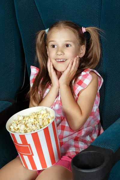 Красивая маленькая девочка смотрит кино в кинотеатре — стоковое фото