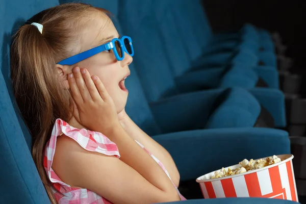 Delighted little girl watching film at the cinema — Stock Photo, Image