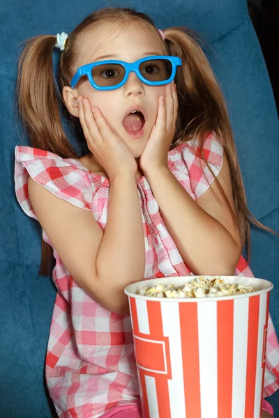 Little girl eating popcorn during a movie — Stock Photo, Image