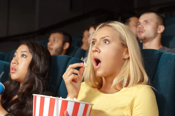 Молодая женщина выглядит испуганной во время просмотра фильма — стоковое фото