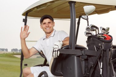 Golfcart arkasında onun sopalarla golfçü