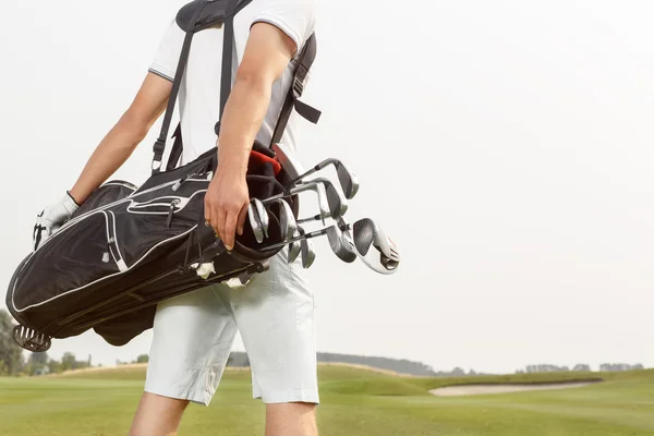 男子携带他的高尔夫球袋跨课程 — 图库照片