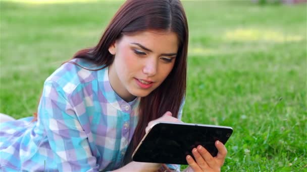 Menina sorridente bonita com touchpad, ao ar livre — Vídeo de Stock