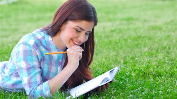 Beautiful girl with her diary in park — Stock Video