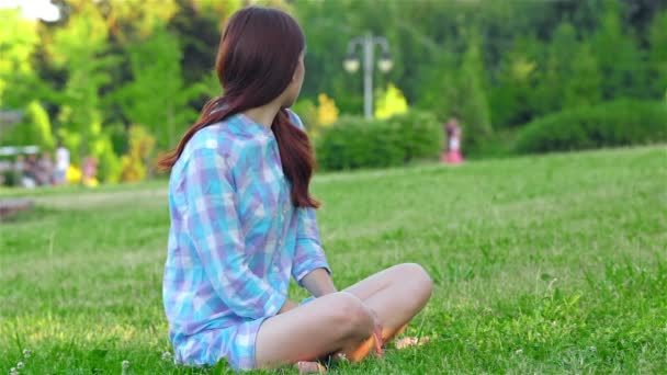 Adolescente faisant du yoga dans le parc . — Video