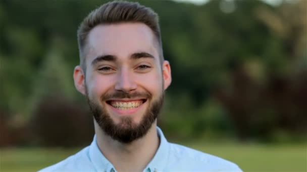 Sonriente hombre guapo en el parque — Vídeos de Stock