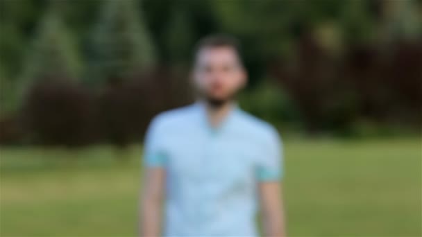 Mosolygó jóképű férfi a parkban — Stock videók