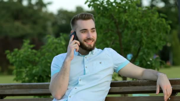 Sorridente bell'uomo che parla al telefono nel parco — Video Stock