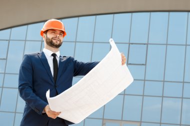 Mimar işçisi inceleme blueprints giyiyor