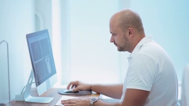 Dentista examina la fotografía de rayos X en PC — Vídeo de stock