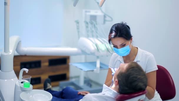 Dentista profissional examinando o paciente — Vídeo de Stock