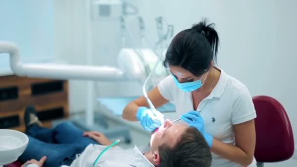 Professionele tandarts installeren vullingen patiënt — Stockvideo