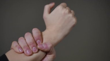 Yakın çekim elleri sıkıca kavrama, nefsi müdafaa talimi sırasında sıkı bilek tutma, gergin eklemler ve görünür damarlar, kapalı alanda nötr arkaplan, eğitmen gösteri