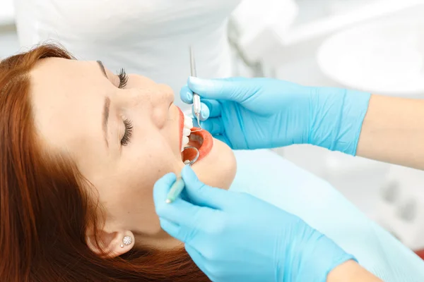 Chica joven que tiene sus dientes examinados por un dentista —  Fotos de Stock