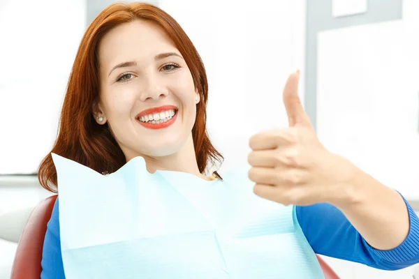 Bir diş hekimleri sandalyede oturan kız