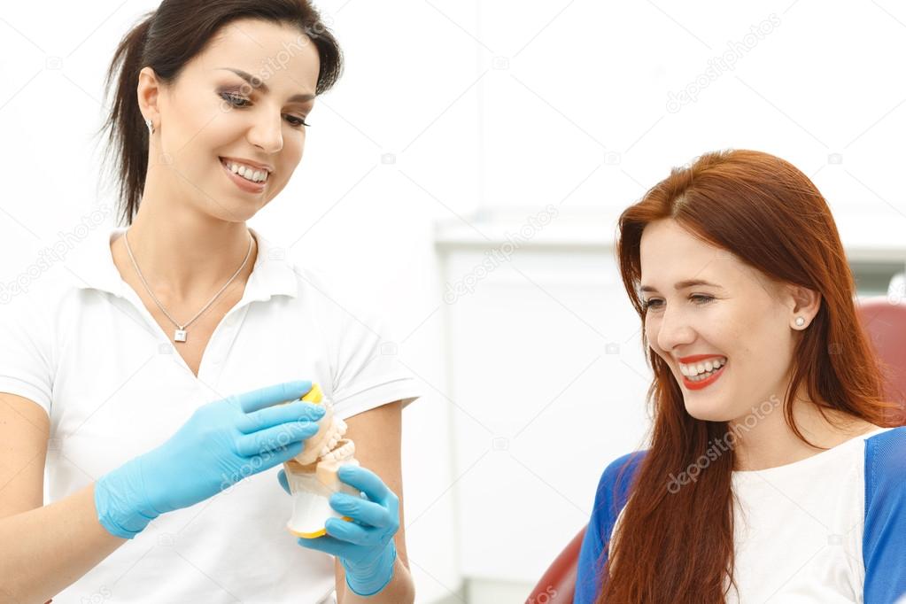 Dentist holding false teeth with patient