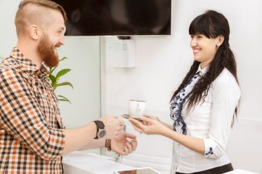 Müşteri bir fincan çay sunan Ofis Müdürü