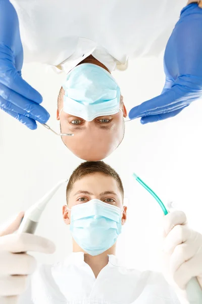 Zahnarzt und seine Assistentin halten Instrumente in der Hand — Stockfoto