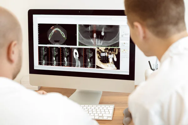 Hammaslääkärit ja avustaja keskustelevat röntgenkuva kuvapankin valokuva