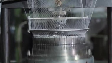 İnce ağ ören endüstriyel örgü makinesi, dairesel iğnelerin yakın çekim görüntüsü görünen iplik metal bileşenleri ve makaralardan narin ağlar oluşturuyor.,