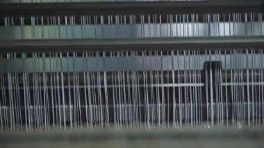 Senkronize iğne hareketi ile çalışan endüstriyel dokuma tezgahı, hızlı dokuma makinesi, ritmik hareketli tekstil üreten fabrika sahnesi