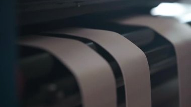 Elastik korse bantları, imalat sırasında dizilimi korumak için erkek eliyle ara sıra rehberlik edilen pürüzsüz bir üretim sürecinde makine silindirlerinin arasından kayar..