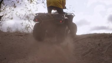 Ağır çekim. Arka manzara binicisi sırt boyunca sürüyor, dramatik arka plan ışığı ve toz bulutu, geniş arazi ağaçları ve gökyüzü, dinamik alçak açılar ve sürüklenen kum,