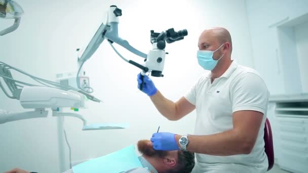 Dentista incluindo microscópio dentário — Vídeo de Stock