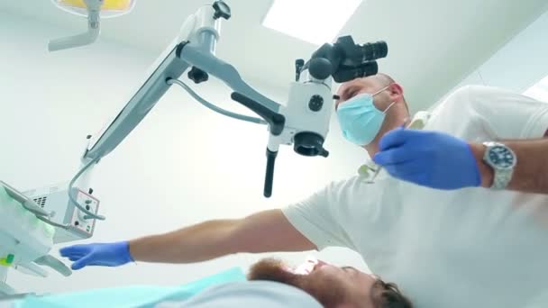Профессиональный стоматолог, осматривающий пациента — стоковое видео