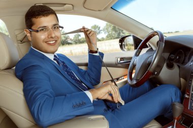 İş adamı arabasını kullanıyor.