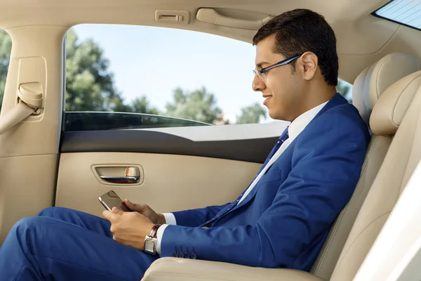 Bir arabanın arka koltuğunda çalışma iş adamı