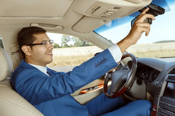 İş adamı arabasını kullanıyor.