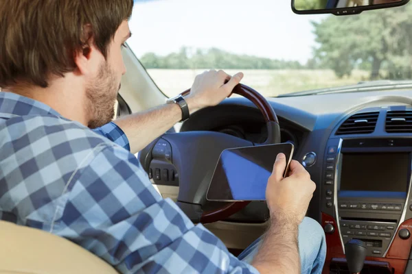 Giovane uomo che utilizza tablet mentre seduto in macchina — Foto Stock
