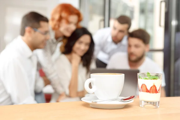 Xícara de café e sobremesa saborosa em uma mesa — Fotografia de Stock