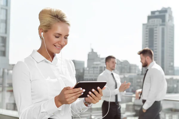 Empresária atraente usando tablet ao ar livre — Fotografia de Stock